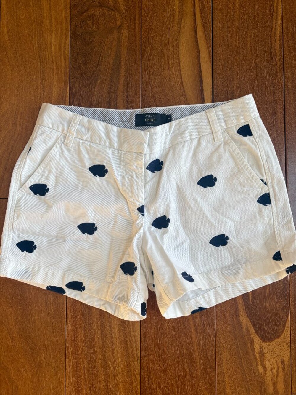J Crew white Chino shorts featuring an all over navy blue embroidered fish motif